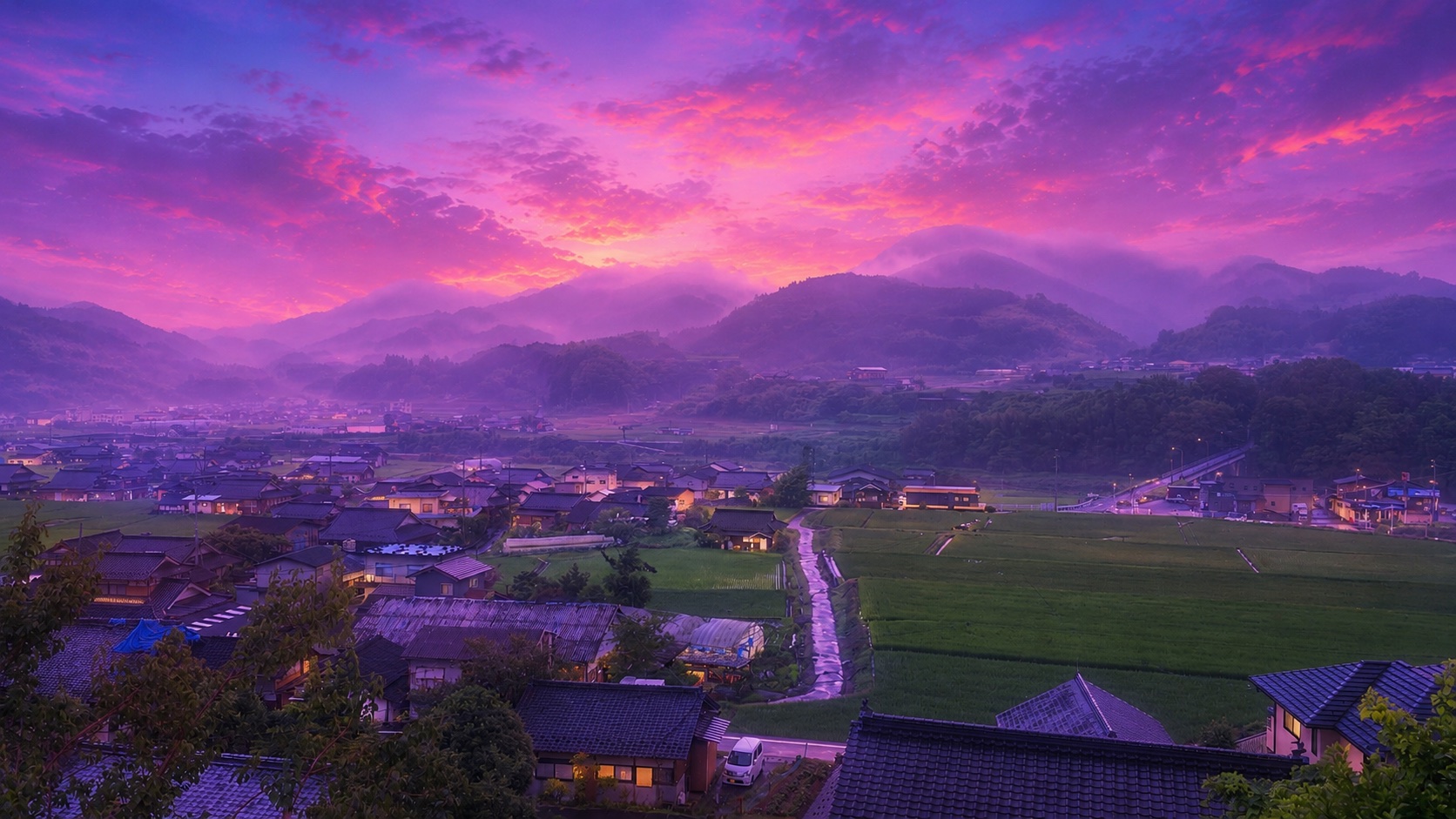 夕暮れの愛媛・西予。霧のかかる山あいに、田んぼと集落の灯りが広がる風景